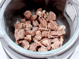 7、牛腩炖萝卜,把焯过水的牛腩放入九 阳蒸汽电饭煲里。