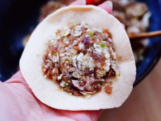 13、全麦牛肉白菜包,在擀好的面皮里，加入适量的搅拌好的馅料。