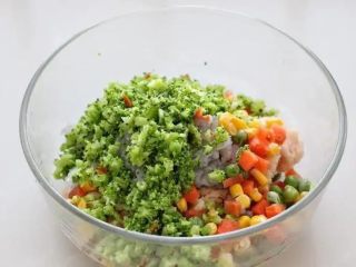 4、鲜虾玉米饼,将西兰花挤干多余水分切碎，同冷冻蔬菜一起放到鸡肉糜中。
