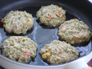 7、鲜虾玉米饼,锅中倒入橄榄油，用勺子舀取适量肉糜放进锅中按压整理成饼状。