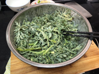 8、蒜泥茼蒿➕蒜泥蒸茼蒿,放入面粉玉米面，抓拌均匀，让茼蒿均匀裹上面粉