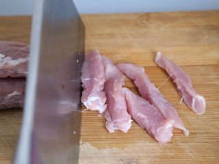 3、酸甜开胃 糖醋里脊,沿着肉的纹理，将里脊肉切成约1厘米宽，5厘米长的条状。