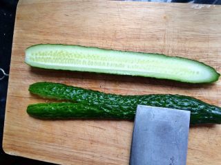 3、＃绿色美食＃开胃菜凉拌黄瓜,冼净的黄瓜对半切开，用刀背拍碎。