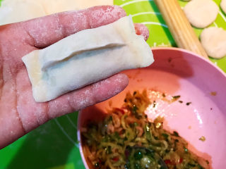 18、牛肉锅贴,取一个面皮，加入1勺馅料，边缘捏合，一个牛肉锅贴生坯就包好了