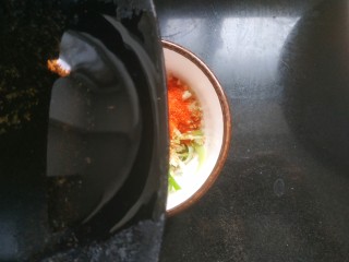 13、凉拌腐竹黄瓜,把热油浇到小碗中