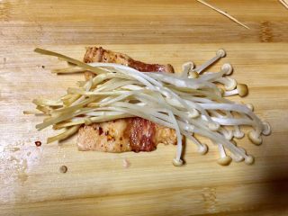 13、#微波炉美食#金针五花孜香卷,现在卷肉，先把肉放下面，金针菇发上面