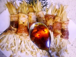 15、#微波炉美食#金针五花孜香卷,裹所有肉裹好后放入喜欢的盘子里，如果喜欢吃辣可以再在金针菇表面倒一些辣椒油，如果吃得清淡就放香油