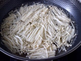 2、金针菇墨鱼丸子汤,金针菇洗净后,用刀切掉根部后焯一下水。