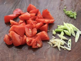 3、金针菇墨鱼丸子汤,番茄洗净后,用刀切成小块,葱姜切丝。