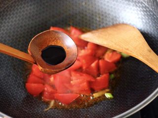 4、金针菇墨鱼丸子汤,锅烧热后倒入花生油,爆香葱姜丝,加入番茄块翻炒均匀,倒入生抽调味调色。