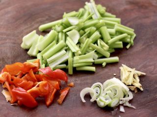 2、香辣八爪鱼,芹菜和红辣椒用刀切成条，葱姜切丝。