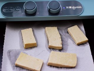 3、香辣煎豆腐,把焯好的豆腐,用厨房用纸吸干豆腐的水分。