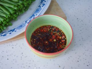 11、酸辣凉豇豆,将刚才的调料碗里加烧熟的香菜油、盐、生抽、香醋、油辣子辣椒、白砂糖，然后搅拌调好。