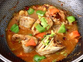 15、啤酒焖鳕鱼,大火继续烧至青红辣椒断生变色的时候，撒上香菜段即可关火。