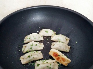 13、早餐锅贴,水分收干后撒上香葱碎即可出锅。
