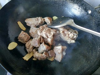 8、#感恩节食谱#   排骨藕汤,倒入排骨翻炒并加入料酒。