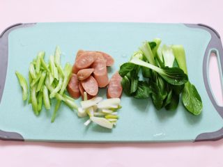 2、营养又养胃的快手火腿肠芹菜炒面,火腿肠斜切成薄片,芹菜斜切成丝,葱切丝,小油菜撕开。