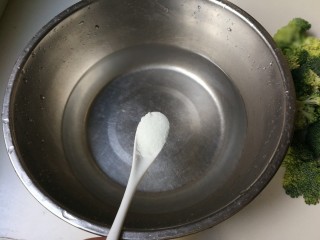 3、蒜泥拌西兰花,盆中放入一小勺盐搅化