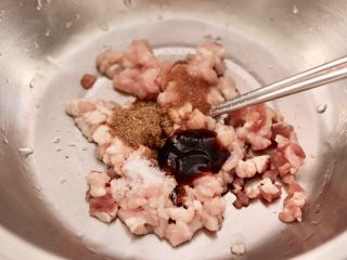 6、肉丁金针菇鱿鱼饺子,猪肉丁里加入花椒粉和蚝油，生抽和味精，生抽和适量的盐调味。