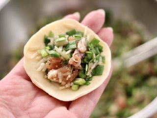 15、肉丁金针菇鱿鱼饺子,面皮上放入适量的馅料。
