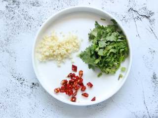 2、酸辣土豆片,蒜去皮剁成蓉，香菜切碎待用。干红辣椒切成小段，一般我会将干红辣椒泡一下水，然后擦干水分待用。这样干红辣椒后面炒的时候不容易炒黑，味道也更香浓些。