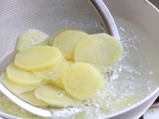 4、酸辣土豆片,煮开一锅清水，水沸加入土豆片焯水，直至土豆片呈半透明状，断生捞出。