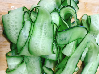 2、凉拌黄瓜卷,刮成长薄片