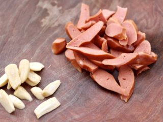 2、小白菜火腿小炒,火腿用刀斜切成薄片，大蒜去皮后切薄片。