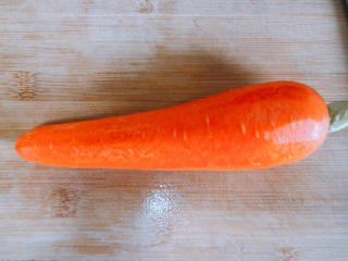 2、胡萝卜炖牛腩,把胡萝卜削皮。