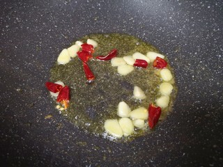 9、莴笋炒虾仁,锅底留余油继续烧热，下入蒜片和干红辣椒炒香。