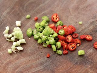 3、照烧北豆腐,把小葱用刀切碎，红尖椒和青尖椒也用刀切成小圈圈。