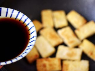 13、照烧北豆腐,这个时候锅中倒入调制好的调料汁，把煎好的豆腐都均匀地沾上调料汁。