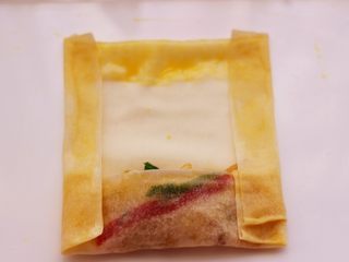 13、土豆丝红椒煎春卷,再把两边对折，如图。