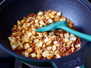 12、牛肉粒香辣藕丁,加入煎好的藕丁,继续快速翻炒均匀后,盖上锅盖中火焖3分钟左右。