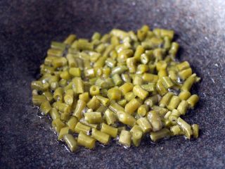 4、绿色美食+酸辣粉,起锅加入20克花生油烧热后倒入酸豆角翻炒断生变色捞出备用