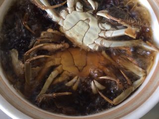 5、黑枣田蟹酒,再把清洗干净的田蟹放入锅中煮15分钟，田蟹反着放防止蟹膏流出