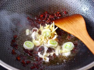 6、啤酒酱焖海鲈鱼,慢慢翻炒出红油香味，倒入葱姜爆香。