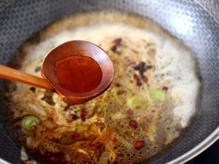 8、啤酒酱焖海鲈鱼,锅中再倒入料酒。