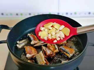8、红烧秋刀鱼,加入切好的姜蒜，辣椒。
