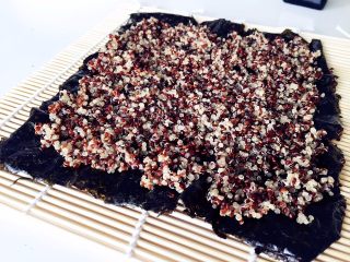 7、健康低卡餐-秘鲁三色藜麦寿司,把寿司海苔放在卷帘上，铺上一层煮熟的藜麦