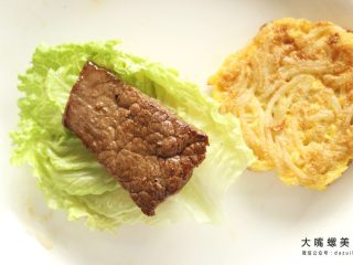 7、你绝对没吃过的螺蛳粉汉堡,将准备好的生菜铺在一块煎好螺蛳粉鸡蛋饼上，放上煎好的牛排/猪排