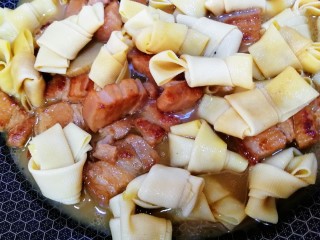 19、千张红烧肉,放入千张结，盖上盖子小火慢炖10分钟，汤汁浓稠即可。