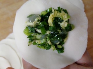 16、韭菜锅贴,勺子舀适量馅，放入面皮中间。