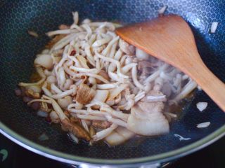 10、花肉白玉菇小炒,加入焯水的白玉菇，继续大火翻炒片刻。