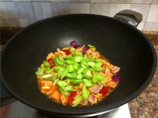 8、西芹泡椒爆鱿鱼,放入西芹翻炒20秒。