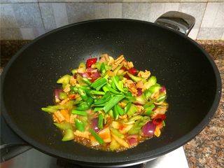 9、西芹泡椒爆鱿鱼,放入青椒和蒜苗翻炒10秒。