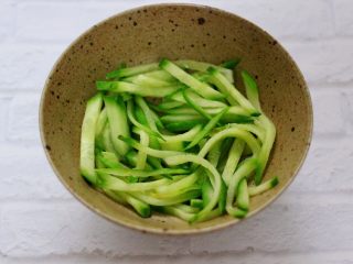 7、上汤干丝,取一个大一点的碗，把焯过水的黄瓜丝铺在底下。