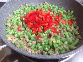 9、豆角炒肉末,加入红椒碎翻炒