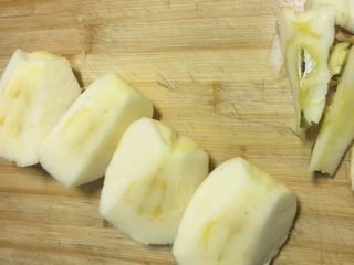 4、甜汤系列之桂花苹果汤,将苹果用刀对半切开在对半切开风四分，将核去掉