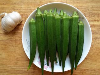1、凉拌秋葵,准备秋葵一盘，蒜半颗。